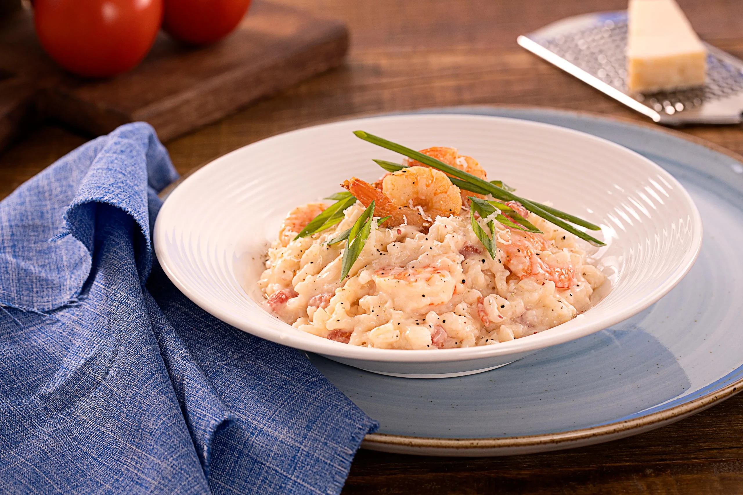 Na imagem, há um prato branco com risoto de camarão