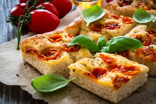 Na imagem, há uma focaccia italiana com queijo e tomate